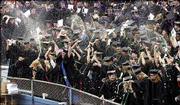 Graduates in the School of Medicine celebrate by popping the cork
on champagne bottles as their degrees are conferred. In all, more
than 4,000 new graduates participated in KU Commencement ceremonies
Sunday at Memorial Stadium.