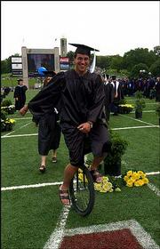 Chris Holzwart, Fort Collins, Colo., opts for alternate
transportation to descend down Campanile Hill and into Memorial
Stadium. Holzwart and his unicycle were in the procession with
members of the College of Liberal Arts and Sciences.