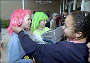 Grant School students, from left, Jennifer Underwood, 11, and her
sister Joslyn Underwood, 10, have their hairstyles admired by
classmate Jamie Fischer, 10. Despite some sadness Friday at Grant,
students celebrated the last day of classes with colorful dress and
festive activities.