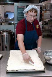 Regina Randel, Baldwin, a cook at the Douglas County Jail, prepares
a meal using supplies by contract vendors. Officials at the jail
are hoping to save money by switching vendors June 1.