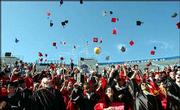 Launching their mortarboards, Lawrence High School graduates,
above, and Free State High School, bottom, students signal the end
of commencement ceremonies Sunday afternoon in Memorial Stadium at
Kansas University.