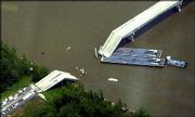 Parts of the collapsed Interstate 40 bridge over the Arkansas River
sit atop a barge near Webbers Falls, Okla. The barge knocked out a
500-foot section of the bridge, sending at least a dozen vehicles
plunging into the water with several people trapped inside,
authorities said.