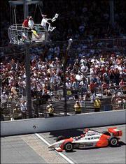 Brazil's Helio Castroneves crosses the finish line to win the 86th
running of the Indianapolis 500. Castroneves became the first
driver to win consecutive Indy 500s since Al Unser Sr. won in 1970
and '71 Sunday in Indianapolis.