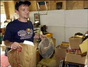 Goodwill employee Joe Crabtree piles up the donations that will
make their way from the 1818 Mass. St. location to Kansas City to
be sorted. Local Goodwill stores had to stop taking donations
temporarily this weekend to catch up with the amount of merchandise
dropped off by students departing for the summer.