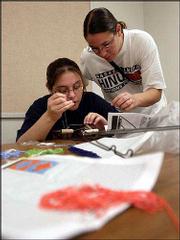 Brandy Juarez, left, Fairview, gets help with her beadwork from
instructor Robin Shield during an Upward Bound Summer Academy
class.