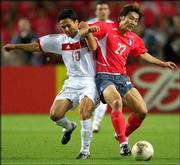 South Korea's Song Chon Gug, right, and Turkey's Yildiray Basturk
go after a possession. Turkey won the third-place World Cup match,
3-2, on Saturday in Daegu, South Korea.