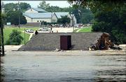 A broken-up home from the Rivercrest subdivision in New Braunfels,
Tex., floats over the Commons Street bridge on the Guadalupe River.
The Guadalupe was flooding from spillway overflow Saturday at
Canyon Lake, Tex. Flooding has led to the evacuation of at least
4,000 Texans.