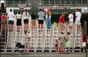 Baseball fans stand on ladders to peer over the left-field wall
outside Joseph P. Riley Park to get a glimpse of the game between
the Charleston Riverdogs and the Columbus Redstixx. Monday was
"Nobody Night" in Charleston, S.C.