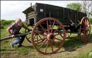 Don Werner works on a covered wagon outside his shop in Horton.
Werner is one of a handful of wagonmakers, or wainwrights, across
the nation. He produces the wagons full time for ranches, tourist
attractions and living history farms.