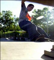 Kenton Smith, 17, Lawrence, hits a front-side nose grind on the
rail during his second run in the skateboard competition.