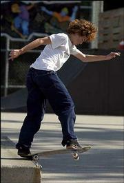 Skateboarder Max Chilenska, 15, Overland Park, does a crooked grind
trick off the fun box at the skate park.