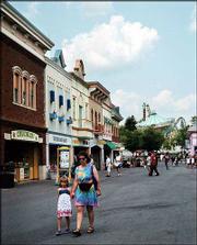 Visitors walk along the Main Street building complex, with a
mid-1800s theme, at Lake Compounce in Bristol, Conn., America's
oldest amusement park. The Main Street complex features skill games
and food booths. The Wave Swinger and the Zoomerang steel roller
coaster are seen in the background.