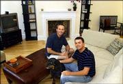 John Repici, left, sits with his partner Adam Slone and their dog
Boomer, in the living room of their new home near Logan Circle in
Washington. Stock market uncertainty has prompted many investors to
look to the real estate market for investments.