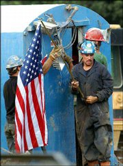 Rescue workers examine a drilling unit at the Quecreek Mine in
Somerset, Pa. Rescuers Saturday eventually saved all nine miners
who had been trapped underground for three days.