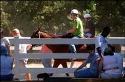 Camp Determination employee Robert McKay, 19, Shawnee, leads a
horse for camper Dana Conroy-Philbrook of Wamego. The camp, which
lasts four days, provides therapeutic horseback riding, art and
music therapy, swimming, fishing, canoeing, hayrides, cookouts,
social skills groups and other activities.