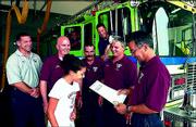 Regional spokesgirl for the Muscular Dystrophy Assn. Jenny McGee,
13, Baldwin, presents a governor's proclamation deeming August
Firefighter Appreciation Month to Lt. Joe Mehl, right, and the
firefighters at Station No. 3, 3708 W. Sixth St. Also pictured on
Monday were, standing, from left, Capt. James Ens, Brian Trigg, Jay
Stalcup and Lt. Dennis Leslie, and inside quint truck, from left,
Joe Hardy and Scott Nissen.
