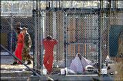 An inmate of Camp X-Ray is escorted by two guards while other
inmates are seen in their cells in Guantanamo Bay U.S. Naval Base,
Cuba, in this March 15, 2002, file photo. The FBI is sending
psychological profilers to interview detainees at Guantanamo Bay.