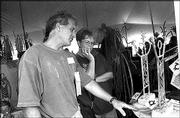 Artist Mark Fischer, left, explains his conceptual interpretation
of a copper sculpture to Linda Ptacek, Overland Park, at last
year's Indian Art Market at Haskell Indian Nations University.