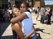 Lawrence High School sophomore Jenesha Jones, left, gets a
first-day-of-school hug from her friend and former schoolmate Janae
Colter during a sophomore picnic at LHS. Colter, who will be a
seventh-grader at South Junior High School, stopped by LHS
Wednesday to hug her sophomore friends whom she will no longer have
as schoolmates.