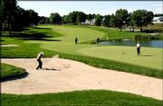 Phillip Prince, left, fires from the sand bunker on to the seventh
green as Stephan Ames, right, watches. The two were preparing
Wednesday for the PGA Championship, which begins today at Hazeltine
National Golf Club in Chaska, Minn.