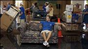 A long line of Kansas University students and their parents wait
their turn for an elevator while fifth-year senior Brett Goering,
Topeka, waits comfortably on his sister&squot;s couch at Oliver Hall.
Students returned Sunday to move into the KU residence halls.
Goering was waiting for his sister, Elizabeth, an incoming
freshman, to reach him in line and help him haul the couch to her
dorm room. "The hard part is yet to come," Goering said.