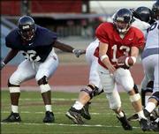 Kansas Quarterback Zach Dyer (13) sets up a handoff as defensive
end David McMillan looks on. The Jayhawks held a one-hour scrimmage
Wednesday at Memorial Stadium.