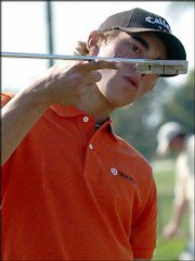 Ty Tryon, of Orlando, Fla., checks out a putter in this Feb. 27
file photo at the Genuity Championship in Miami. Tryon, the
youngest player to earn a PGA Tour card, didn't get a chance to use
it this summer.