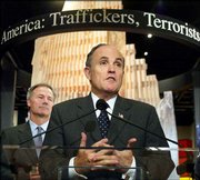 Standing in front of a scene of the World Trade Center devastation,
former New York City Mayor Rudy Giuliani helps launch a new exhibit
at the Drug Enforcement Administration Headquarters in Arlington,
Va., as DEA Director Asa Hutchinson listens at left. The display,
called "Target America," draws connections between terrorism and
drug trafficking.