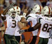 Miami's Jason Geathers (3) celebrates with quarterback Ken Dorsey,
center, and David Williams after catching a fourth-quarter
touchdown pass. Top-ranked Miami hammered Florida, 41-16, on
Saturday in Gainesville, Fla.