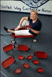 Kristen Malloy, co-executive director for Partnership for Children
and Youth, sits in a red wagon that symbolizes America&squot;s Promise
slogan: "Pull your weight." The wagons can be purchased on the
organization&squot;s new Web site, www.lawrencedouglas countypromise.org,
which will be accessible to the public on Tuesday.