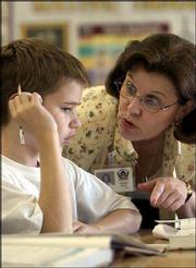 Quail Run school fifth-grader Brain Gauch, left, gets advice from
his teacher, Christine Valcich, while working on some math
exercises. Gauch and his classmates were working on graphing
lessons Tuesday. Quail Run achieved the state's standard of
excellence in math and reading.