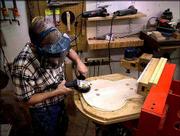 Palen grinds down a piece of wood to be used for the back of a
guitar. He uses caliper to determine the back's thickness. During
the past three years, Palen has earned the respect of jazz
guitarists throughout the world, including famed jazz guitarist and
singer George Benson, who bought one of Palen's creations.