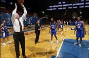 KU athletic director Al Bohl, left, shoots hoops during a break in
media day at Allen Fieldhouse as assistant Maggie Mahood, middle,
and Nichelle Roberts look at.