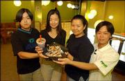The Pochi Tea Station, 125 E. 10th St., is introducing Lawrence
customers to bubble tea. The restaurant is run by family members
from left, Bao Quan Cai, 27, Ervana Tjhai, 17, Erlinda Tjhai, 24,
and Agustiwan Tjhai, 20. The restaurant, which opened about two
weeks ago, serves drinks and Indonesian dishes.