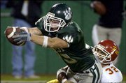 Northwest Missouri State running back Mitch Herring, left, reaches
out as he puts the ball into the end zone. The Bearcats hammered
Pittsburg State, 29-7, on Thursday at Arrowhead Stadium.
