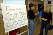 Carolyn Masinton, left, who has three children at Cordley School,
1837 Vt., discusses a proposal to close the school with fellow
Cordley parent Denise Copp. Masinton distributed information at the
school before Monday night's Lawrence school board meeting, where
Cordley parents and others discussed a districtwide facilities
plan.