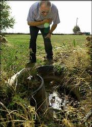 Rex Still, division manager of environmental health services for
the Fulton County Health Department, shows off likely mosquito
breeding grounds in Dunfermline, Ill. Illinois was the state hit
hardest by the West Nile virus, transmitted by mosquitoes. A hard
frost will kill off mosquitoes, and with them, the deadly virus.
