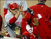 Anaheim's Troy Glaus, left, is greeted by teammates after scoring
on a Scott Spiezio triple in the third inning. The Angels beat the
Giants, 10-4, in Game 3 of the World Series on Tuesday in San
Francisco.