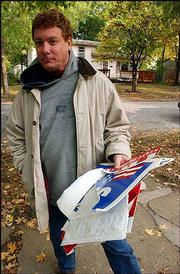 Rich Minder collects political signs strewn across his yard in the
1500 block of Rhode Island Street. Lawrence Police said they found
sporadic yard sign damage on Tuesday, apparently targeted toward
Democratic campaign materials.
