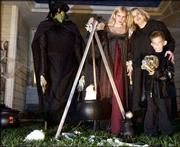 Niki Osburn, middle, and her family Kirsten, 13, and Ryan, 6, are
sure to spook their share of trick-or-treaters this Halloween.
Pictured at left is their life-size witch with her cauldron.