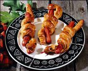 Snaky Hallowieners are a fright-night delight. They are made by
winding snaky shapes of bread dough around franks, then baking them
in the oven to serve hot with ketchup and gooey mustard.