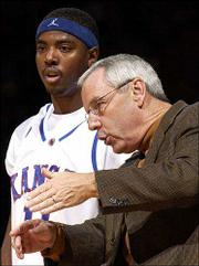 KU coach Roy Williams, right, instructs guard Aaron Miles. Williams
will face his alma mater Wednesday when the Jayhawks play North
Carolina in the Preseason NIT semifinals at New York.