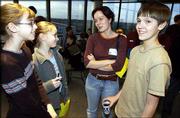 Members of the Lawrence children's choir, Justine Ahle, 12, and
Lindsay Gauthier, 12, at left, speak with Moscow Boys Choir member
Volodya Fadin, 14, with the help of interpreter Yana Grigortchouk,
a Kansas University graduate student from Petrozavodsk, Russia,
center, during a choir exchange at the Lied Center. The two choirs
met on Saturday, prior to the Moscow Boys Choir's performance that
evening. Choir members talked with the help of interpreters and
learned that they have a lot more in common than they thought they
would. Later, Lawrence choir members got to listen to the Moscow
Boys Choir's dress rehearsal.
