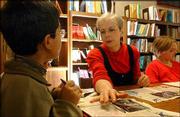 Majed Al Shalaan, a fourth-grader at Hillcrest School, receives
some help from Susan Peterson, right, a library-media specialist at
the school, 1045 Hilltop Drive. Peterson is among a number of
school librarians expected to retire by 2014.
