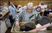 Linda Lassen, Penn House director, center, and Jo Lee Erskin, Penn
House coordinator, left, put together some gift packages from the
agency's collection of donated items. Penn House and several other
United Way agencies will adopt families for the holidays and will
provide food and gift packages. At left with Jo Lee is Seth Quick,
4.
