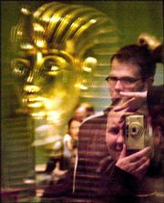 The gold mask of King Tutankhamun is reflected in glass as a
tourist takes a photo inside the Egyptian museum in Cairo. The
Egyptian Museum, which was opened in 1902, began celebrations
Monday to mark its centenary anniversary.