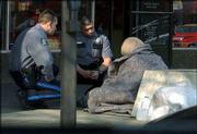 Lawrence Police officer Leo Souders talks with a homeless person on
Massachusetts Street to see if he needed assistance getting to a
shelter. More homeless are seeking Lawrence services, officials
report.
