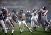 Chicago Bears quarterback Jim Miller (15) hands the football to
running back Leon Johnson behind the blocking of Kevin Dogins (73)
and Olin Kreutz (57) during a heavy rainstorm. The Dolphins
defeated the Bears, 27-9, on Monday at Pro Player Stadium in Miami.