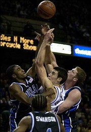 Kansas senior Nick Collison is sandwiched between Tulsa's Antonio
Reed, left, and Jack Ingram, right, while fighting for a rebound.
The Jayhawks survived a scare from the Golden Hurricane, 93-85,
last December at Kemper Arena in Kansas City, Mo. Tonight the
Jayhawks will travel to Tulsa for a rematch.