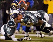 Philadelphia's Brian Dawkins (20) and Barry Gardner (52) stop St.
Louis running back Marshall Faulk during a Dec. 1 game in
Philadelphia. Dawkins was one of seven Eagles selected for the Pro
Bowl on Thursday.
